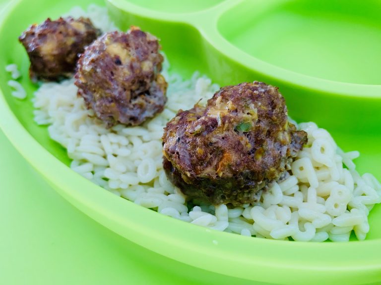 Hidden veggie meatballs served over pasta on a kids plate