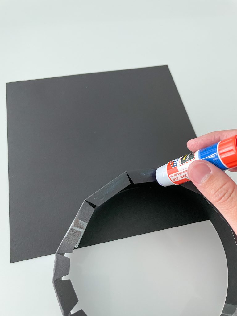 Attaching the paper band to the underside of the graduation cap